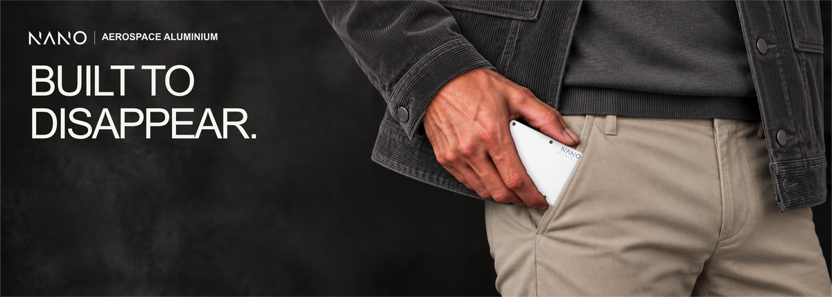 NANO Carrera White aerospace aluminium AirTag cash strap wallet — sliding into a trouser pocket
