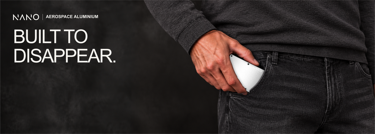NANO Ghost Silver aerospace aluminium cash strap wallet — sliding into a trouser pocket