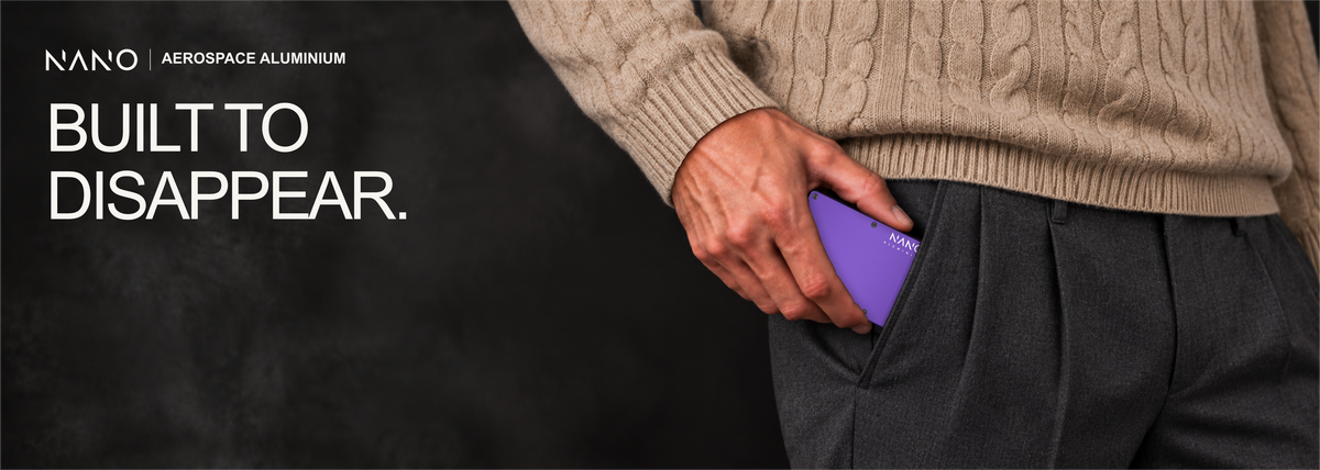 NANO Nebula Purple aerospace aluminium AirTag cash strap wallet — sliding into a trouser pocket