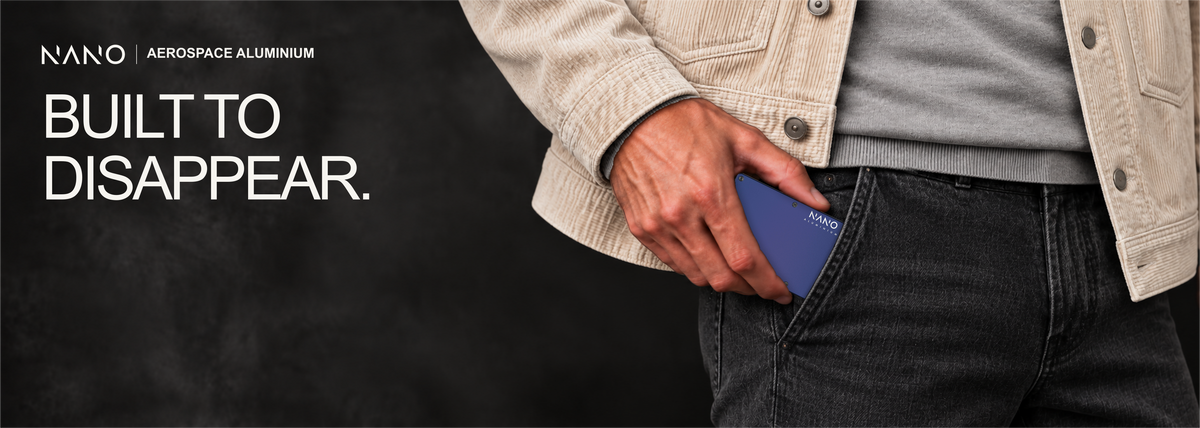 NANO Skyfall Navy aerospace aluminium AirTag cash strap wallet — sliding into a trouser pocket
