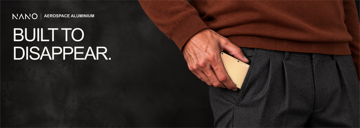NANO Spectre Gold aerospace aluminium cash strap wallet — sliding into a trouser pocket