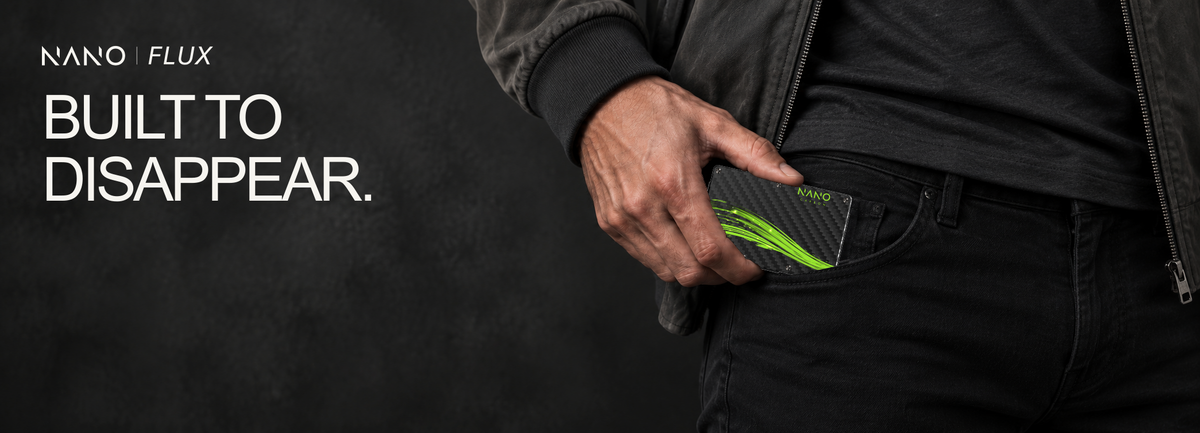 NANO FLUX — Built to disappear. Volt Green wallet held at a front pocket with a charcoal bomber and black jeans.