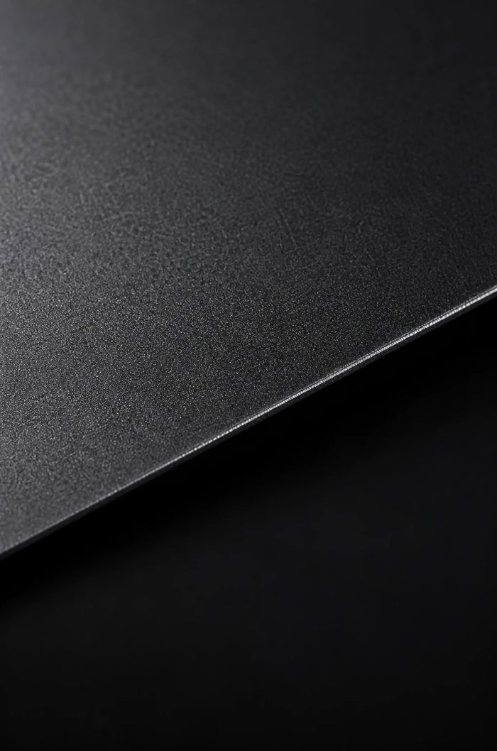 Close-up material study of a dark anodised aluminium surface