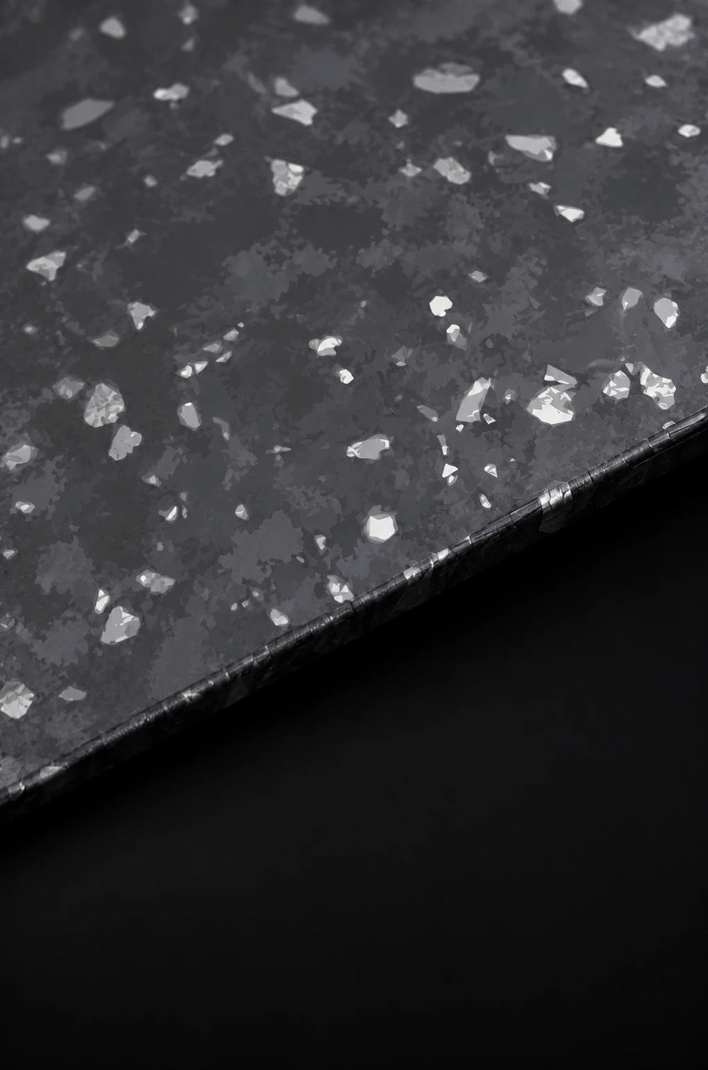 Close-up material study showing the irregular pattern of forged carbon.