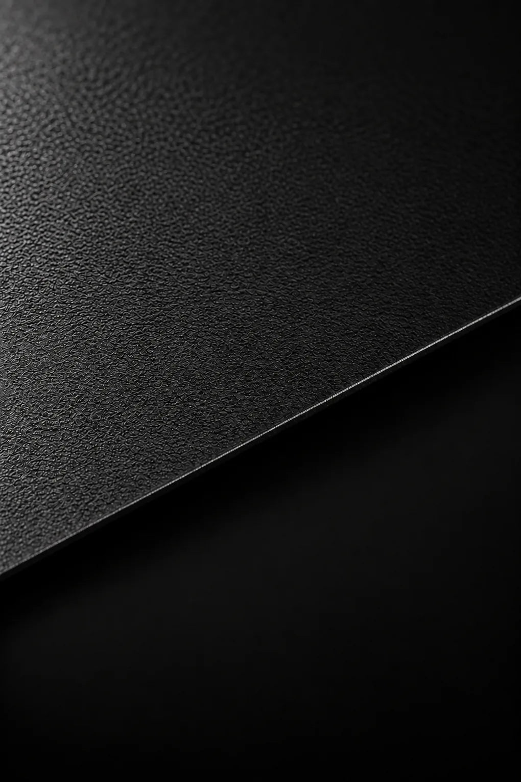 Black powder-coated aerospace aluminium with a textured finish and a crisp diagonal edge.